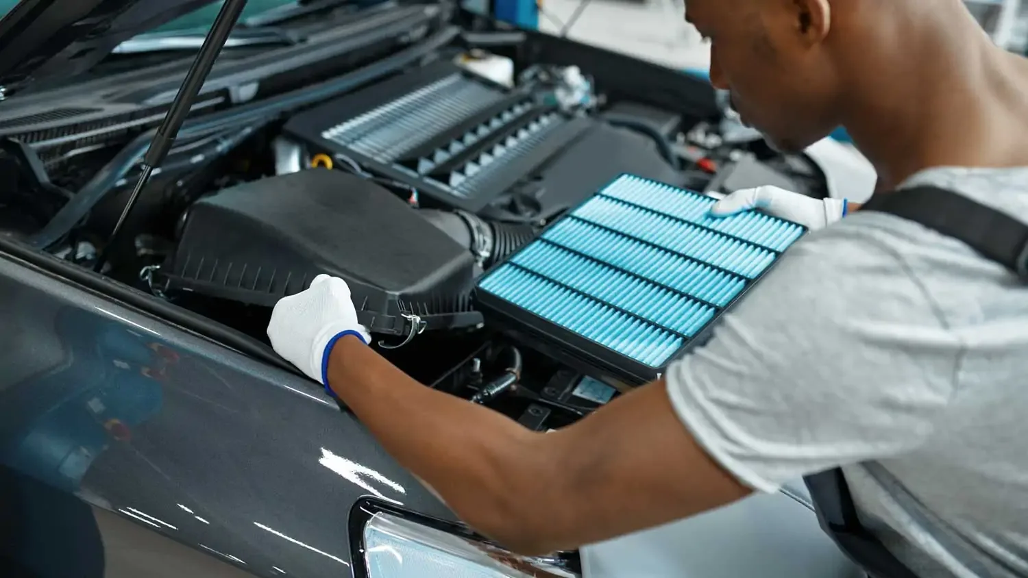 Mechanic fitting a new air filter into a car’s air cleaner box